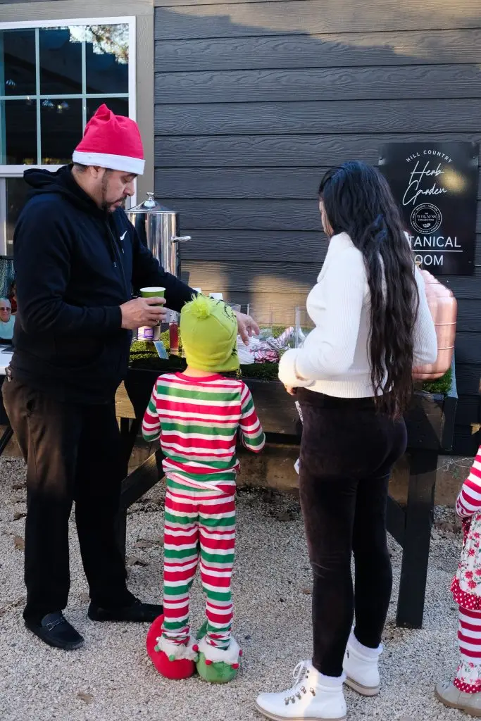 Kids and family enjoying the hot chocolate station at Santa in the Garden event in Fredericksburg, Texas