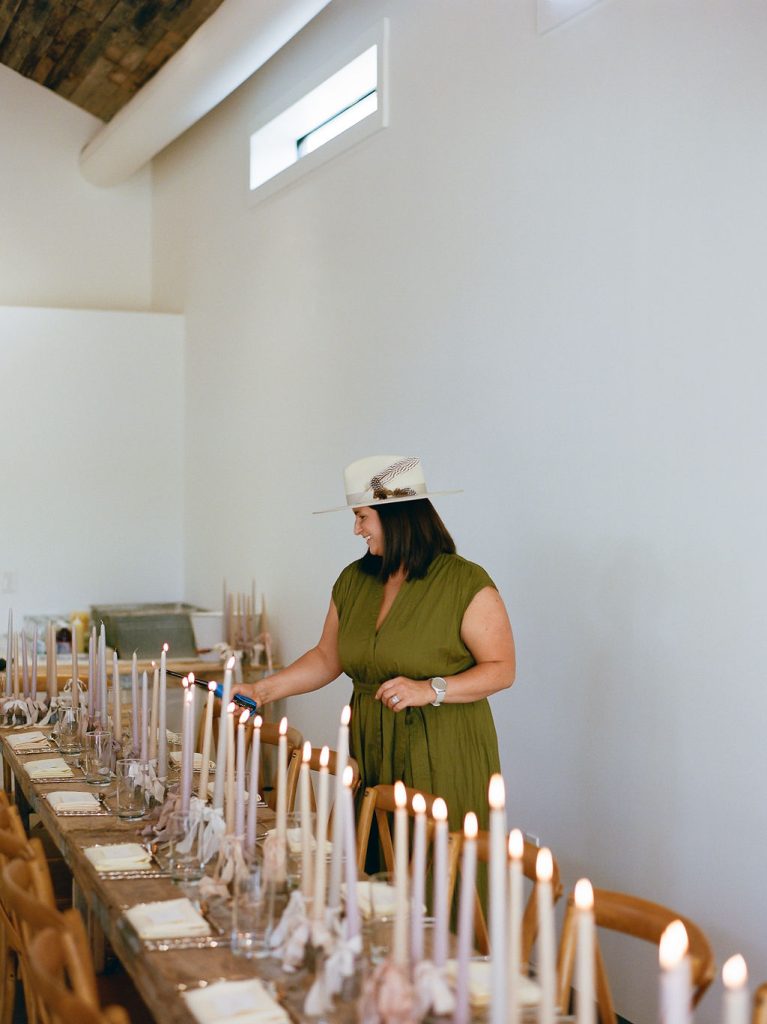 Woman lighting candles for a private rehearsal dinner at Hill Country Herb Garden