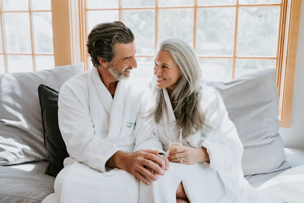 A couple enjoys a glass of champagne in their robes at Hill Country Herb Garden Spa.